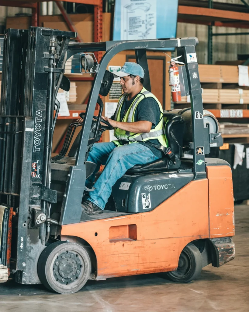 A forklift being operated in a warehouse.
