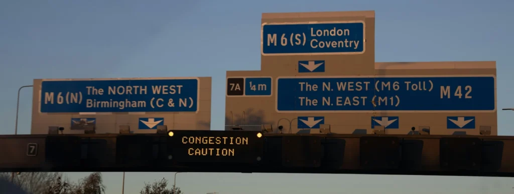 A motorway junction with blue signs, including directions for the M6 to London