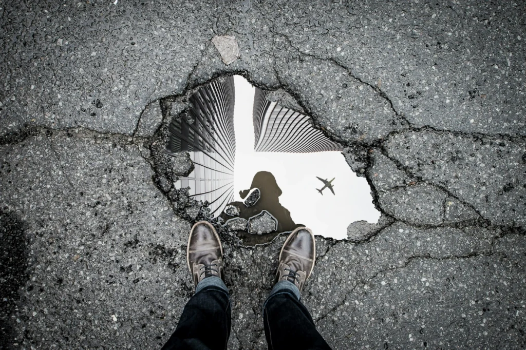 A deep pothole filled with rainwater.