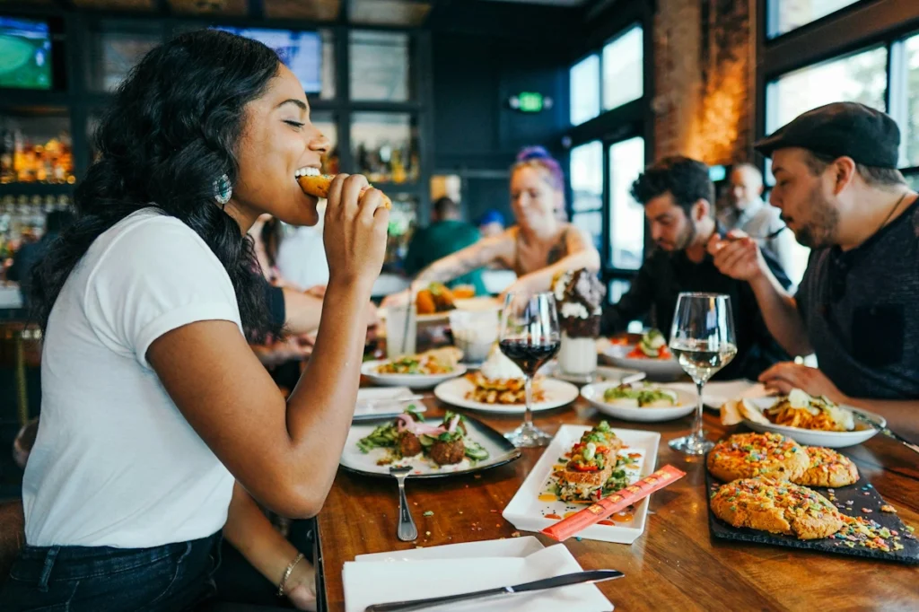 A table full of people eating a meal in a restaurant.